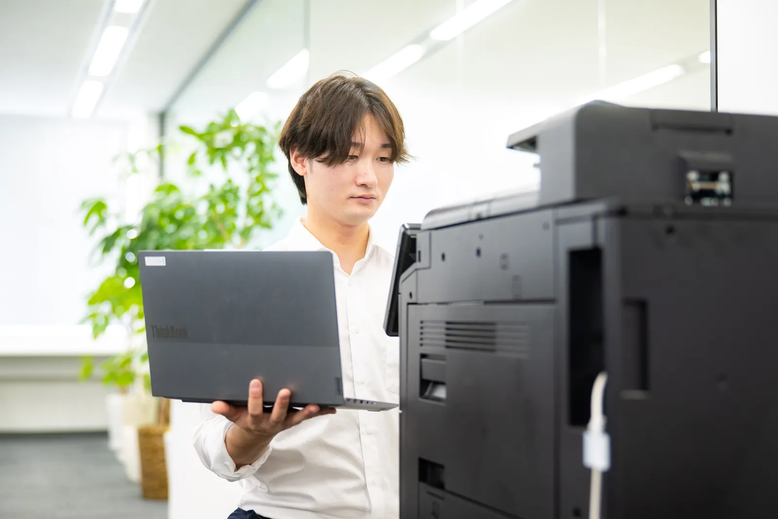 ノートPCを片手にコピー機の対応をするCEメンバー